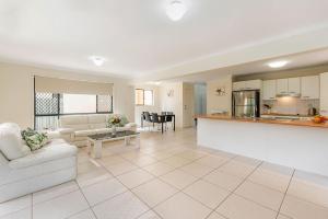 a living room with a couch and a kitchen at Bluefin in Noosaville
