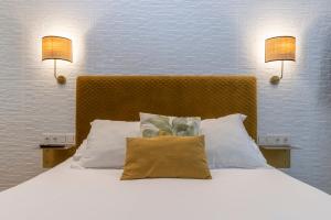 Un dormitorio con una cama con dos lámparas en la pared. en BIG 4 ROOMS in a Centric Home Parking Included, en San Sebastián