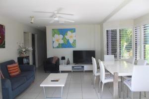a living room with a table and a tv at 1 Aarons Villa in Noosaville +5 photos