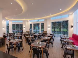 a restaurant with tables and chairs and a red couch at favehotel Kediri in Kediri