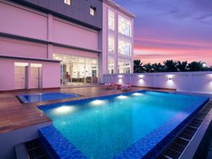 a swimming pool in front of a building at favehotel Kediri in Kediri