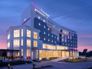 un gran edificio con un cartel de hotel en favehotel Kediri, en Kediri