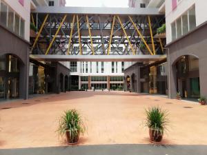 a large building with two potted plants in a courtyard at Hotel MetraSquare in Melaka