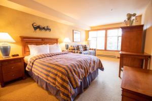 a hotel room with a bed and a chair at 3309B - Queen Standard Powderhorn Lodge condo in Solitude