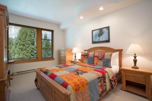 a bedroom with a bed and two lamps and a window at 4312 - Two Bedroom Deluxe Creekside Condominiums condo in Solitude