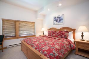 a bedroom with a large bed with a red bedspread at 4312 - Two Bedroom Deluxe Creekside Condominiums condo in Solitude