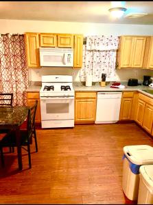 a kitchen with wooden cabinets and a white stove top oven at Large 3-Bedrooms/2-Bath Apt, One Block to Train in Brooklyn