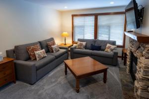 a living room with two couches and a fireplace at 3201 - Two Bedroom Standard Powderhorn Lodge condo in Solitude