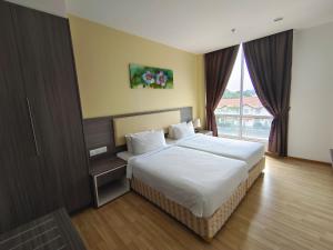 a bedroom with a bed and a large window at Hotel MetraSquare in Melaka