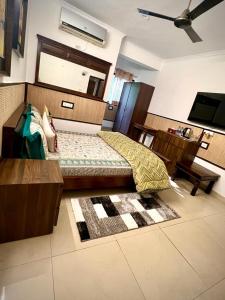 House Of Comfort Delhi في نيودلهي: غرفة نوم بسرير وتلفزيون بشاشة مسطحة