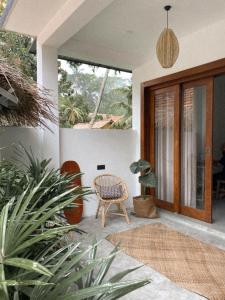 Hiriketiya的住宿－Clics Coliving & Coworking，一个带藤椅和盆栽的庭院