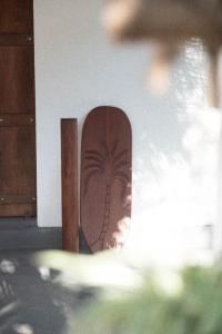 uno skateboard appoggiato a un muro con una palma sopra di Clics Coliving & Coworking a Hiriketiya