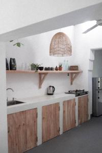 eine Küche mit Holzschränken, einer Spüle und einer Theke in der Unterkunft Clics Coliving & Coworking in Hiriketiya