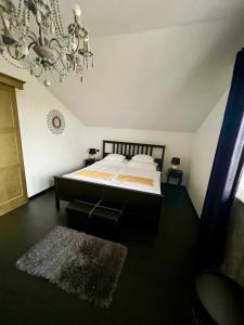 a bedroom with a bed and a chandelier at Gold Horse Vendégház in Szilvásvárad