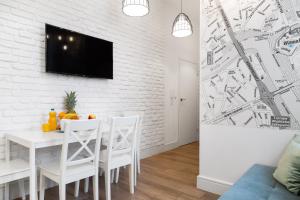 a white dining room with a white brick wall at Househost Apartment: Bonerowska 5/19 in Krakow