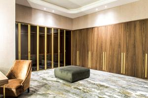 a dressing room with a chair and a ottoman at Rixos Turkistan in Türkistan