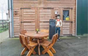 una mesa de madera y sillas frente a un cobertizo en Pet Friendly Home In Beltrum With House A Panoramic View, en Beltrum