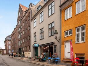 un grupo de edificios en una calle con mesas y sillas en Sanders Saint - Loft One-Bedroom Apartment By the Charming Canals, en Copenhague