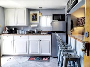 a kitchen with white cabinets and a stainless steel refrigerator at Cozy Apartment near SFO in San Bruno