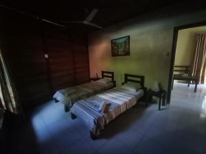 una camera con due letti in una stanza con di Cakalang Resort a Bunaken