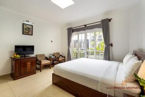 a bedroom with a bed and a tv and a window at LILA Hotel & Apartments in Ho Chi Minh City
