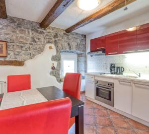 uma cozinha com cadeiras vermelhas e uma mesa num quarto em Countryside Child Friendly Homes Dutovlje - Happy Rentals em Dutovlje