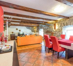 uma sala de estar com uma mesa e cadeiras vermelhas em Countryside Child Friendly Homes Dutovlje - Happy Rentals em Dutovlje