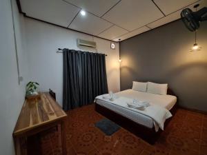 a bedroom with a bed and a table in it at Saphaothong guesthouse in Vang Vieng