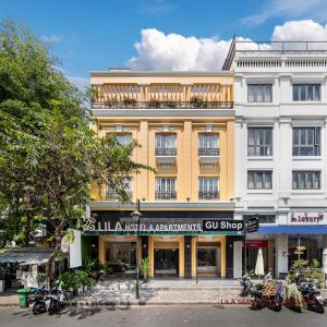 un grand bâtiment jaune avec des motos garées devant lui dans l'établissement LILA Hotel & Apartments, à Hô-Chi-Minh-Ville