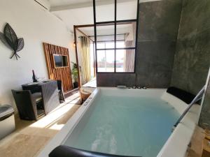 a large bath tub in a room with a television at "The Love Room Bandol" Jacuzzi & Vue Mer in Bandol