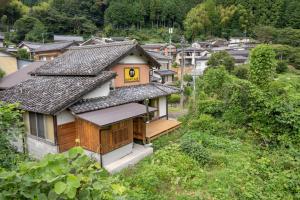 una vista aérea de una casa en un pueblo en 古民家一棟貸し宿　山のめぐみ舎, en Niyodogawa
