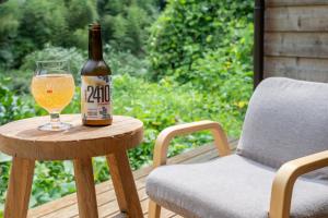 a bottle of beer sitting on a table next to a chair at 古民家一棟貸し宿　山のめぐみ舎 in Niyodogawa