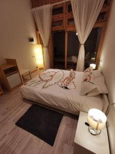 a bedroom with a bed with curtains and a table at Origami Inn Himandhoo in Himandhoo 