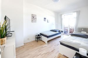 1 dormitorio blanco con 2 camas y ventana en Modern & Chic Apartment with Balcony, en Gravenbruch