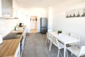 cocina y comedor con mesa blanca y sillas en Modern & Chic Apartment with Balcony, en Gravenbruch