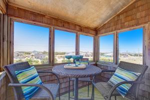 un porche cubierto con sillas y mesa en Pelican Paradise 770, en Avon
