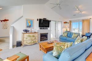 Una sala de estar con un sofá azul y una chimenea. en Pelican Paradise 770, en Avon