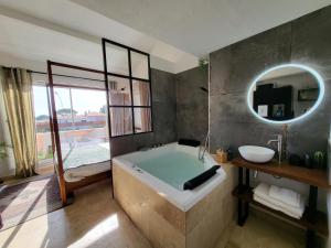 a bathroom with a bath tub and a mirror at "The Love Room Bandol" Jacuzzi & Vue Mer in Bandol