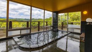 a room with a large pool in the middle of a building at Kyukamura Taishakukyo in Shōbara