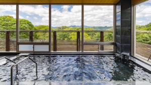 Shōbara的住宿－Kyukamura Taishakukyo，带窗户的客房内的热水浴池