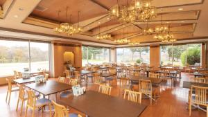 a restaurant with tables and chairs and large windows at Kyukamura Taishakukyo in Shōbara +50 photos