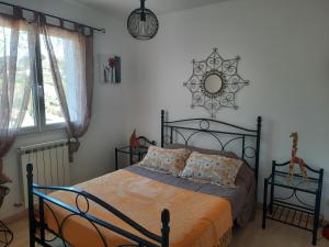 een slaapkamer met een bed en een spiegel aan de muur bij MAISON/PISCINE 5mn de Bayonne 12 de Biarritz in Mouguerre