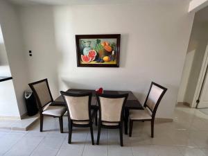 a black table and chairs with a painting on the wall at Aparment Rosarito Beach Downtown (C) in Rosarito +8 photos