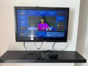 a television sitting on a table with two remote controls at Aparment Rosarito Beach Downtown (C) in Rosarito