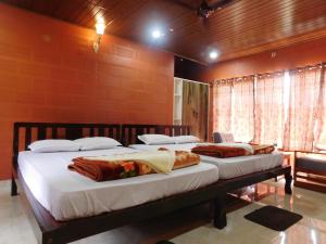 a bedroom with two beds in a room at Cauvery Homestay in Somvārpet