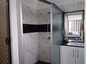 a bathroom with a shower and a sink and a mirror at Bula Holiday Inn in Nadi