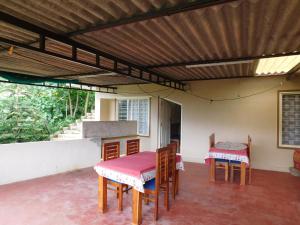a patio with a table and chairs in a room at Cauvery Homestay in Somvārpet