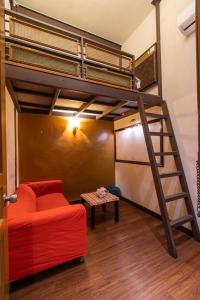 a living room with a loft bed and a red couch at Travel Hub Highstreet in Kuala Lumpur