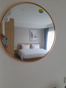 a bedroom with a bed and a round mirror at Happy Home in Nha Trang