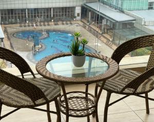 a table and chairs on a balcony with a swimming pool at KSL Desplanade By Antlerzone in Johor Bahru